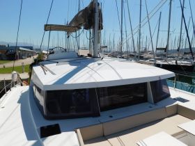 A clear view of a catamaran docked at the marina, showcasing its sleek design and spacious deck, perfect for sailing adventures.