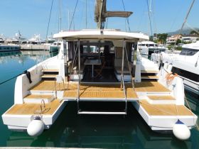 A stunning view of a catamaran docked in a marina, showcasing its spacious deck and modern design — perfect for luxury sailing experiences.