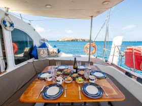A beautifully arranged dining area on a yacht featuring a variety of delicious dishes and drinks, perfect for enjoying meals while cruising on the open water.