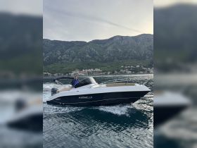 A Marinello speedboat glides through the water with a scenic mountainous backdrop, perfect for exploring coastal destinations.