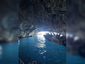 A thrilling boat adventure through a stunning cave, showcasing the vibrant blue waters and the excitement of exploring hidden gems on the coast.