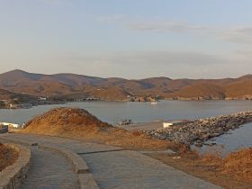 A scenic view of a harbor surrounded by hills, capturing the tranquil atmosphere of the area.
