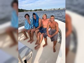 A group of friends relaxes on a boat, enjoying a summer day on the water — perfect for creating lasting memories and fun adventures.