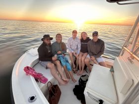 A group of friends enjoys a sunset on a boat, creating a perfect backdrop for memorable moments and celebrations on the water.