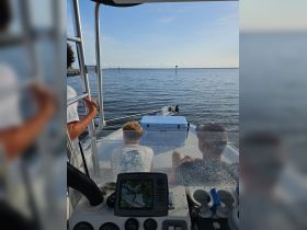 A family enjoys a day on the water, with children seated on the boat while navigating through calm waters — a perfect setting for fishing or exploring.