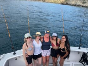 A group of friends poses on a fishing boat, ready for a day of adventure on the water. Perfect for capturing memories during a fun fishing trip.