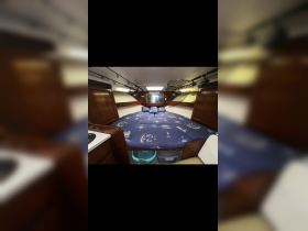 Cozy interior cabin of a boat featuring a spacious sleeping area with decorative bedding and storage space, ideal for comfortable overnight stays on the water.