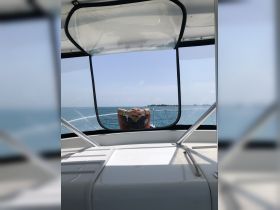 A guest relaxes on the deck of a boat, enjoying the scenic ocean view — a perfect moment for unwinding on the water.