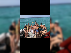 A lively group enjoys a fun day on the water, holding conch shells while celebrating together on a boat — perfect for memorable snorkeling adventures.