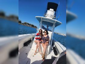 Two friends enjoy a sunny day on a boat, capturing the essence of relaxation and fun on the water.
