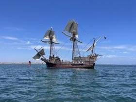 A majestic sailing ship navigates through clear waters, showcasing its impressive sails and classic design — perfect for maritime enthusiasts and historical tours.