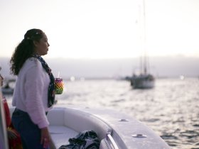A woman enjoys a drink while taking in the sunset views from the boat, capturing the essence of a relaxing evening on the water.