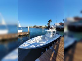 A sleek speedboat docked at the marina, showcasing its design against a clear blue sky — perfect for water adventures.