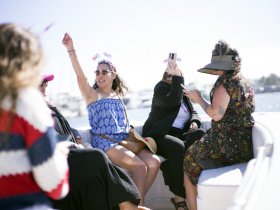 A lively group of friends celebrates aboard a boat, capturing joyful moments and enjoying the sun — perfect for memorable outings and gatherings on the water.