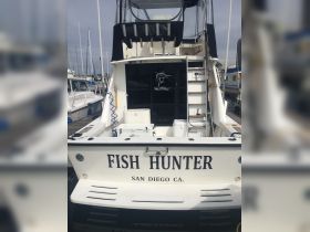 The rear view of the 'Fish Hunter' boat docked in San Diego, showcasing its sleek design and fishing capabilities.