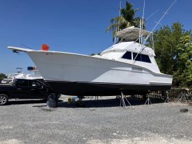 A striking view of a yacht on dry dock, showcasing its sleek design and structure under a clear blue sky.