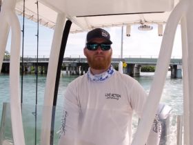 A captain navigates a fishing boat through a scenic waterway, showcasing the thrill of sportfishing adventures.