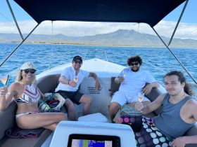 A cheerful group enjoys cocktails aboard a boat, celebrating with stunning views in the background — perfect for memorable outings on the water.