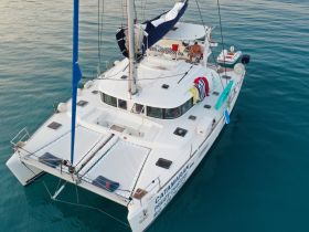 Aerial view of a catamaran showcasing its spacious deck and vibrant colors, perfect for private charters and leisurely sailing adventures.