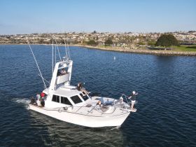A lively group enjoys a fishing trip aboard a boat, capturing the excitement of their adventure on the water.