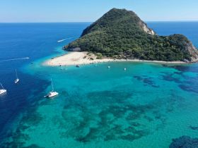 A stunning aerial view of a secluded island with a sandy beach and crystal-clear waters, perfect for exploring and relaxing in nature.