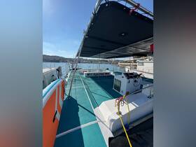 Interior view of the spacious deck area on the catamaran 'PLAYTIME', featuring comfortable seating and a well-equipped helm, perfect for relaxing and enjoying the water.