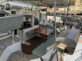 Interior view of a yacht's cabin featuring comfortable seating and a helm area, perfect for relaxing or navigating on the water.