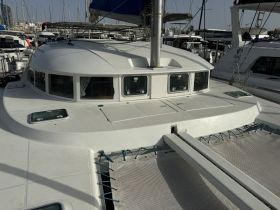 A close-up view of a catamaran's deck, showcasing its sleek design and features while docked at the marina.