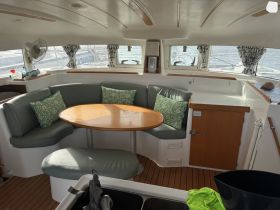 A cozy interior view of a catamaran featuring a comfortable seating area and dining table, perfect for relaxing and enjoying meals while on the water.