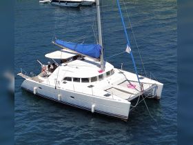 Aerial view of a catamaran anchored in clear waters, showcasing its spacious design and inviting atmosphere for leisurely sailing adventures.