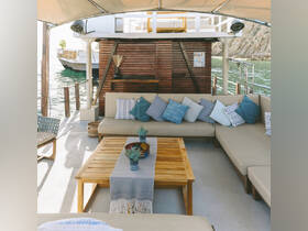 A cozy lounge area inside a boat featuring comfortable seating and decorative pillows, perfect for relaxing while enjoying the scenic views.