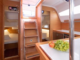 A beautifully designed interior of a sailboat featuring a cozy cabin, modern kitchen area, and a welcoming atmosphere, perfect for relaxing during your nautical adventures.