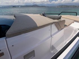A stylish lounge area on a boat, featuring comfortable seating and a scenic view of the water, perfect for relaxing during a day on the sea.