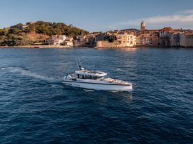 A sleek speedboat glides through the clear waters, showcasing a picturesque coastal town in the background — perfect for exploring scenic destinations.