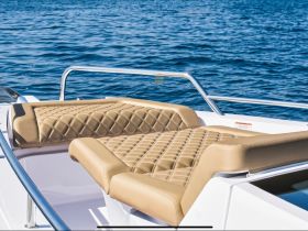 Luxurious seating area on a boat, featuring plush cushions and a sleek design, perfect for relaxing while enjoying the open water.