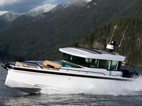 A sleek speedboat glides through the water, showcasing its modern design against a backdrop of lush mountains — perfect for adventurous outings on the water.