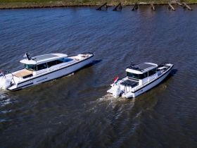 Aerial view of two sleek yachts cruising through calm waters, showcasing their elegant design and perfect for leisurely outings.