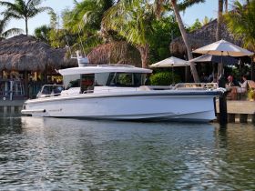 A sleek yacht docked at a tropical location, surrounded by palm trees and a vibrant atmosphere, perfect for luxury getaways and day trips.