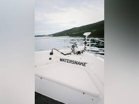 A close-up view of the helm area on a boat featuring the 'WATERSNAKE' branding, showcasing the console and equipment, perfect for fishing or leisure outings.