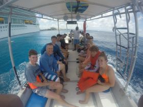 A lively group of guests aboard a boat, ready for an exciting snorkeling adventure in crystal-clear waters. Perfect for family outings or group excursions.