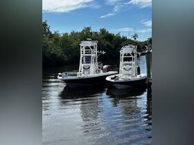 Two sleek speedboats docked in calm waters, surrounded by lush greenery, showcasing the perfect setting for a day on the water.