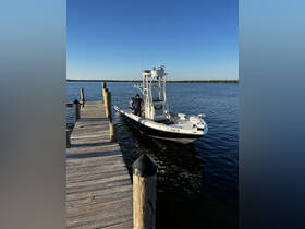 A sleek speedboat is docked at the pier, with a person preparing for an adventure on the water. Ideal for fishing or leisurely cruises.