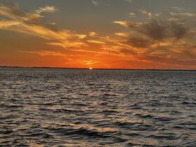 A stunning sunset over tranquil waters, perfect for capturing the beauty of evening boat rides and scenic views.