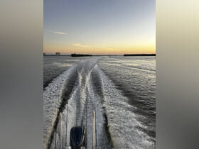 A stunning view from the back of a boat, showcasing the wake as it navigates through calm waters at sunset — perfect for capturing the essence of boating adventures.