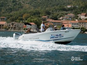 A lively group enjoys a speedboat tour, cruising through beautiful waters with scenic coastal views in the background.