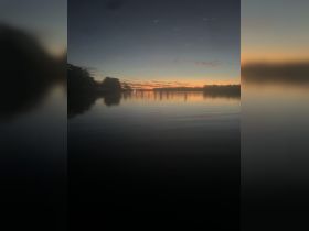 A serene sunset over calm waters, reflecting vibrant colors — a perfect backdrop for evening boat trips or peaceful moments on the water.