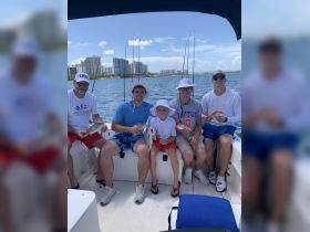 A joyful family fishing trip on a boat, showcasing their catch of the day against a scenic backdrop — perfect for creating lasting memories on the water.