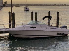 A Wellcraft boat docked at sunset, showcasing its sleek design against a tranquil waterfront backdrop.