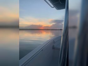 A serene sunset view from the side of a boat, reflecting beautiful colors on calm waters — perfect for peaceful evening cruises.