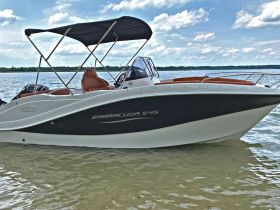 A sleek Barracuda 545 boat captured from the side, showcasing its stylish design against a serene water backdrop — perfect for leisurely outings.